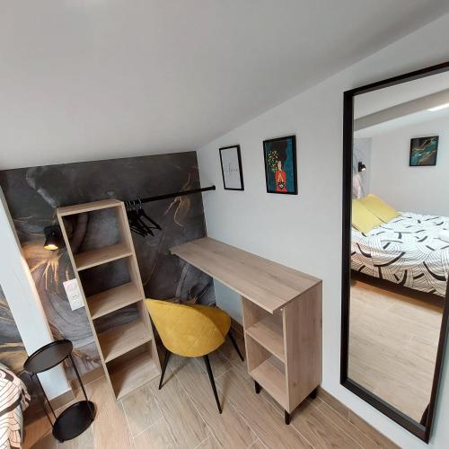 a room with a desk and a bed and a mirror at Résidence Tamaris Loft House in La Mézière