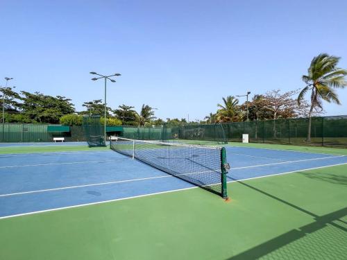 a tennis court with a net on top of it at Villa De Palma -Oceanfront community w generator in Sabana
