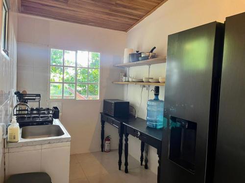 a small kitchen with a sink and a refrigerator at La Veranda Hotel & Restaurant in Minca