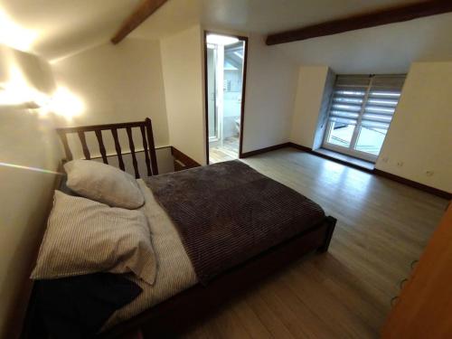 une chambre avec un lit dans une pièce dans l'établissement Petite maison de village, à Chamouilley