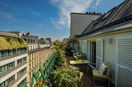 Cet appartement dispose d'un balcon avec une table et des chaises. dans l'établissement Luxueux Appartement, avec terrasse vue Champs-Élysées, à Paris