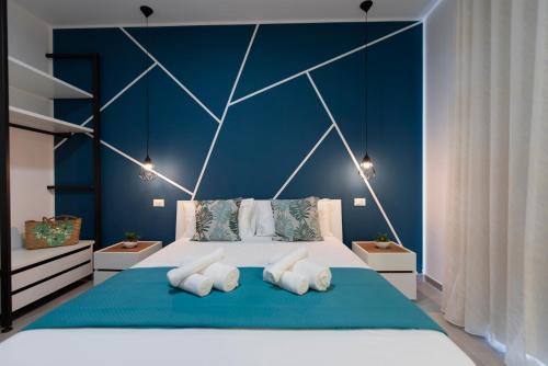 a blue bedroom with a large bed with four pillows at Bed and Breakfast Da Francesca in Castelluzzo