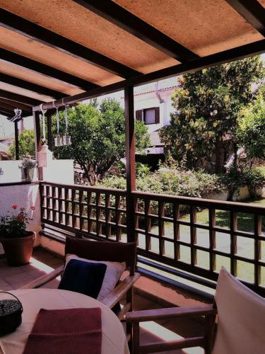a porch with a table and chairs on a balcony at Orsiida Seaside Cottage KGatzea in Kato Gatzea