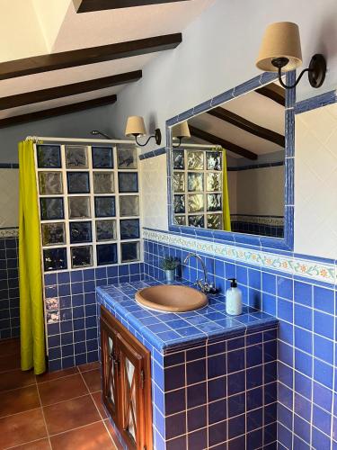 a blue tiled bathroom with a sink and a mirror at Mayte Dreams Caminito Del Rey in Valle de Abdalagís