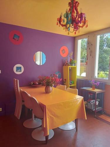 une salle à manger avec une table et un mur violet dans l'établissement Grande maison familiale spacieuse , agréable et calme, à Landeronde
