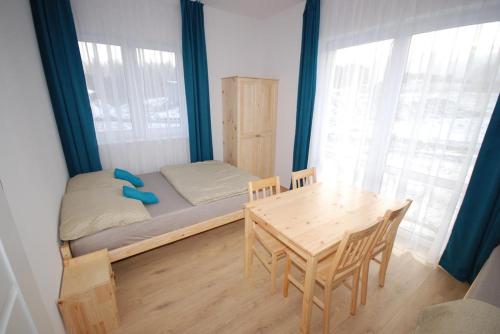 a bedroom with a bed and a table and chairs at Pęglity jezioro in Gietrzwałd