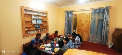 a group of people sitting at a table eating at Moonshine Homestay Kashmir in Srinagar