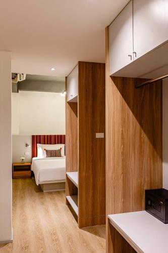 a bedroom with a bed in a room with wooden walls at At Thaphae Hostel in Chiang Mai