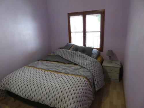 a bedroom with a bed and a window at Au Bonheur Suspendu in Pont-en-Royans