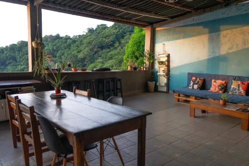 a dining room with a table and a couch at La Bohème Casa Cultural - Santa Teresa in Rio de Janeiro