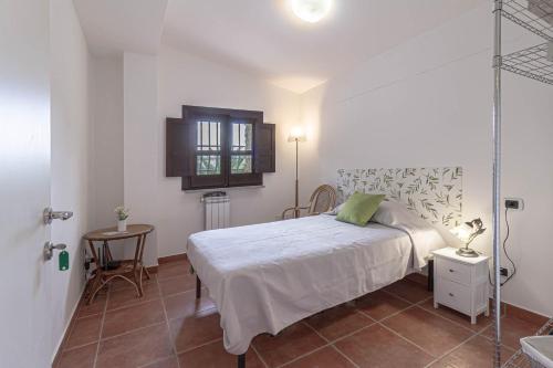 a bedroom with a bed and a table and a window at Il Castello degli Ulivi-Agriturismo in natura in Roccella Ionica
