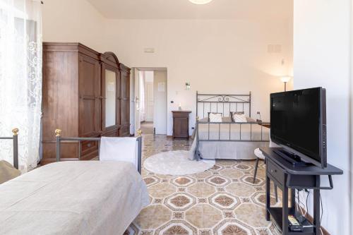 a bedroom with a bed and a flat screen tv at Il Castello degli Ulivi-Agriturismo in natura in Roccella Ionica