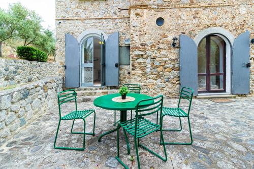 a green table and chairs on a patio at Il Castello degli Ulivi-Agriturismo in natura in Roccella Ionica
