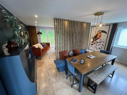 a living room with a wooden table and a couch at Trewhiddle Retreat V5 by Together Travel - Luxury 4-Bedroom Villa in St Austell