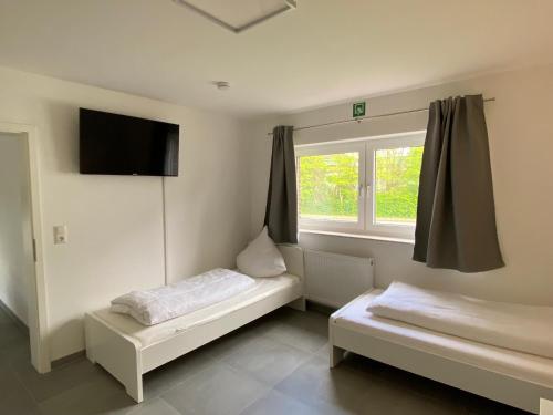 ein Zimmer mit zwei Betten und einem Fenster in der Unterkunft OWL Comfort Homes - Porta Westfalica in Porta Westfalica