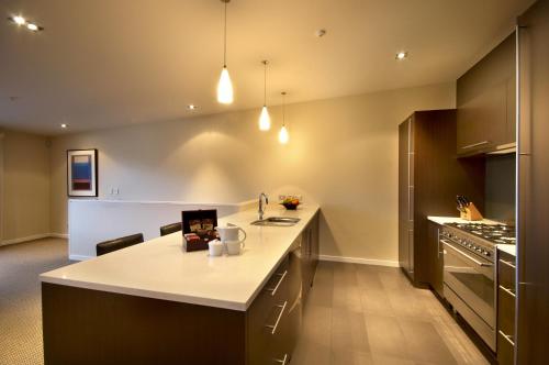 a kitchen with a white counter top and a stove at LakeRidge Queenstown by Staysouth in Queenstown