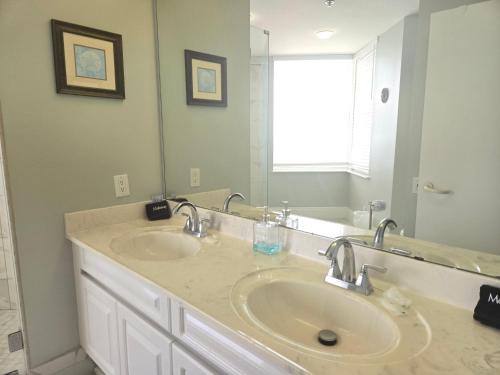 a bathroom with two sinks and a large mirror at Beach Colony 18A in Pensacola