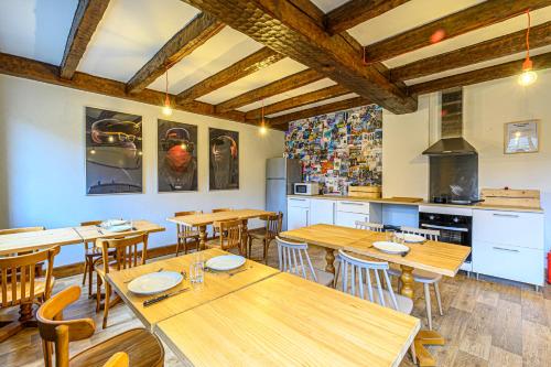 a restaurant with wooden tables and chairs and a kitchen at Naéco Erdeven in Erdeven