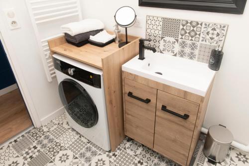 a bathroom with a washing machine and a sink at L'Elégant des Remparts, vue sur chateau fort in Sedan