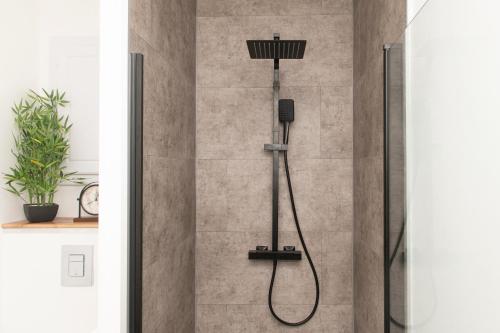 a shower with a shower head in a bathroom at L'Elégant des Remparts, vue sur chateau fort in Sedan