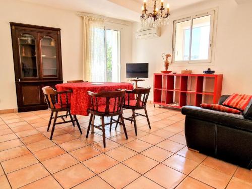 - un salon avec une table et des chaises rouges dans l'établissement BANYULS, T3 climatisé à 50m de la plage, en centre-ville - FR-1-309-9, à Banyuls-sur-Mer