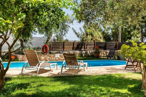 two chairs and a swimming pool in a yard at Villa Aloni in Fílippos
