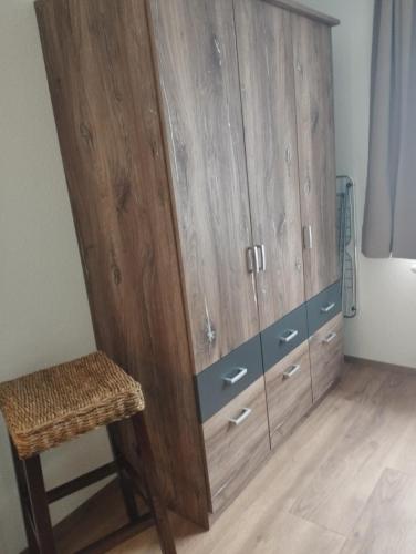 a large wooden cabinet with a chair in a room at Kathis Burgblick in Rottenmann