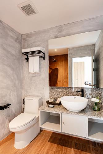 a bathroom with a white toilet and a sink at At Thaphae Hostel in Chiang Mai