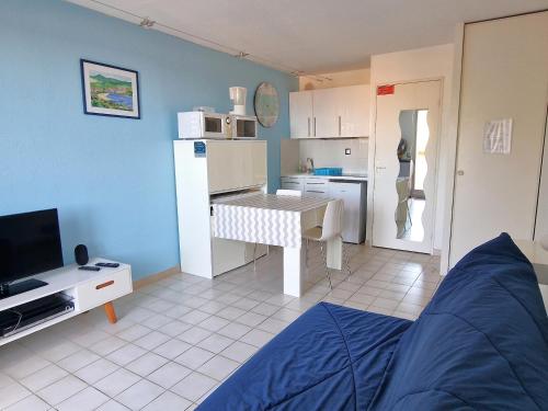 Cette chambre comprend une cuisine et une table avec un lit. dans l'établissement Joli studio terrasse 2* proche centre, parking, vue mer - FR-1-309-140, à Banyuls-sur-Mer