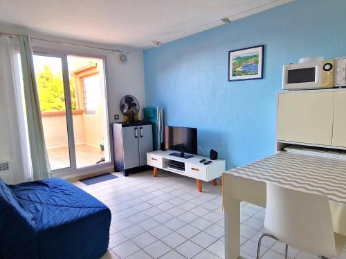 un salon avec une pièce bleue avec un micro-ondes dans l'établissement Joli studio terrasse 2* proche centre, parking, vue mer - FR-1-309-140, à Banyuls-sur-Mer
