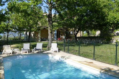 une piscine avec des chaises et une clôture dans l'établissement Colombelle, à Bonnieux