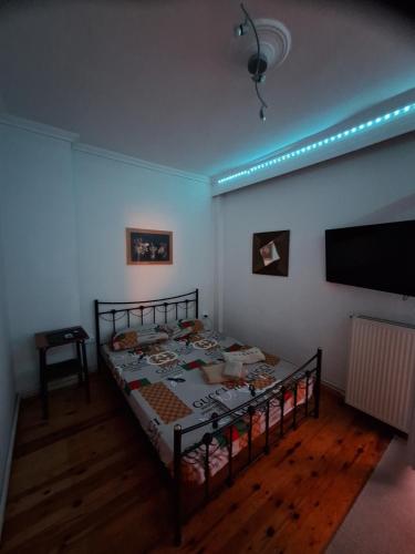 a bedroom with a bed and a flat screen tv at Queen Suites Family Friendly 60m2 in Thessaloniki