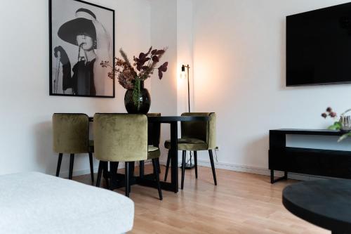 a living room with a table with a vase of flowers on it at JUNIK Apartments "Am Sternbuschweg" in Duisburg