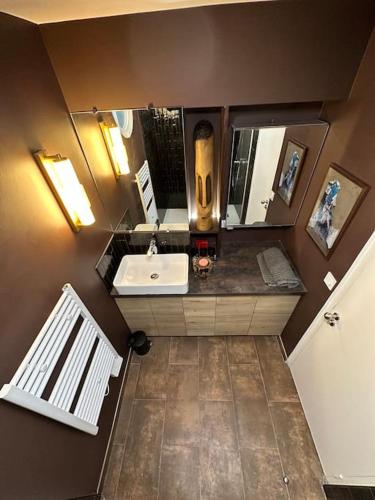 une salle de bain avec un lavabo et un miroir dans l'établissement Appartement Triplex refait à neuf à Bastille, à Paris