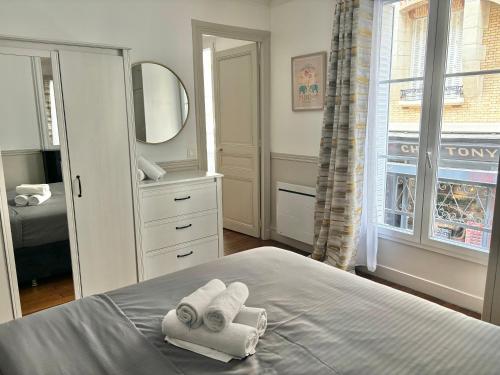 - une chambre avec 2 serviettes sur un lit et un miroir dans l'établissement SUITE ELISE Passy, à Paris