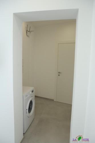 a laundry room with a washing machine and a door at La Vite in Locogrande