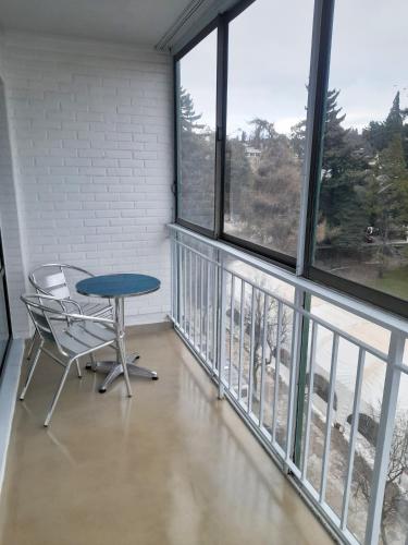 a table and chair in a room with windows at Viena II by Tirol in San Carlos de Bariloche
