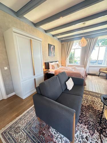 a bedroom with a bed and a couch in a room at De Stadshoeve in Medemblik
