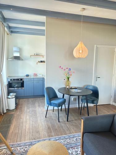 a living room with a table and chairs and a kitchen at De Stadshoeve in Medemblik