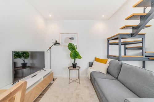 a living room with a couch and a tv at Campolide Duplex Apartments in Lisbon