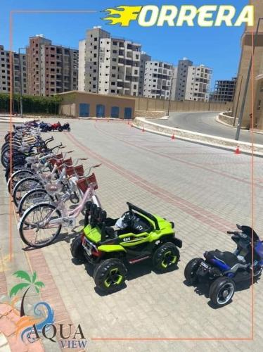 a row of motorcycles andicycles parked in a parking lot at قريه اكوا فيو الساحل الشمالي العلمين in El Alamein