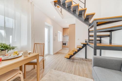 a kitchen and living room with a dining table and stairs at Campolide Duplex Apartments in Lisbon