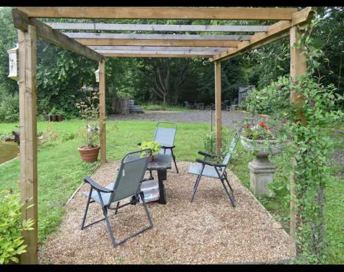 two chairs and a table under a pergola at Squirrels-oaks in Yalding