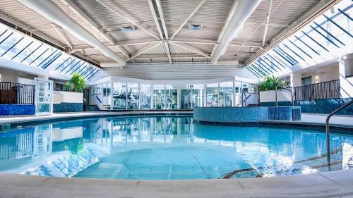 a large pool with blue water in a building at The Aberdeen Dyce Hotel in Dyce