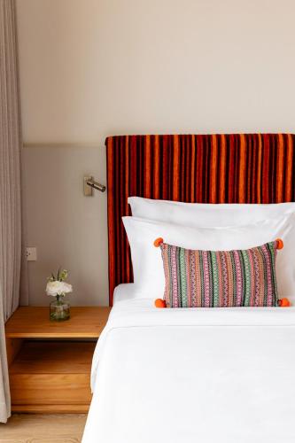 a bedroom with a white bed with a pillow at At Thaphae Hostel in Chiang Mai