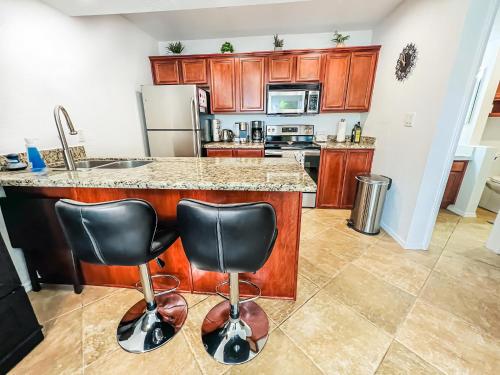 a kitchen with a counter and two bar stools at Cozy & Peaceful Sedona Condo with Pool, walk to Restaurants, Shops & Hiking Nearby in Sedona