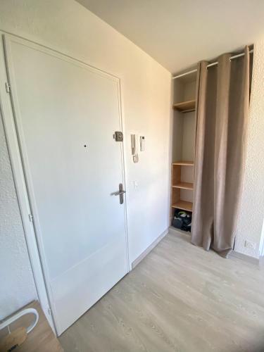 une pièce vide avec une porte et un placard dans l'établissement Le Belvédère - Studio avec vue YourHostHelper, à Montpellier