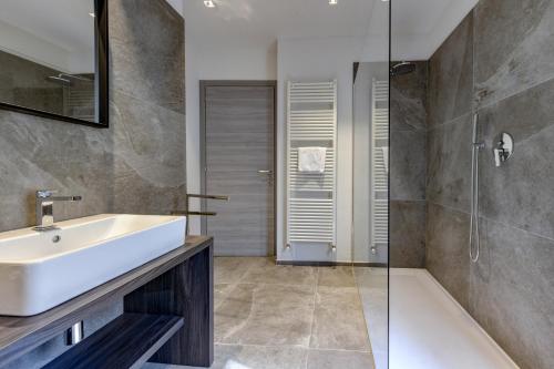 a bathroom with a white sink and a shower at Hotel Tripoli in Desenzano del Garda