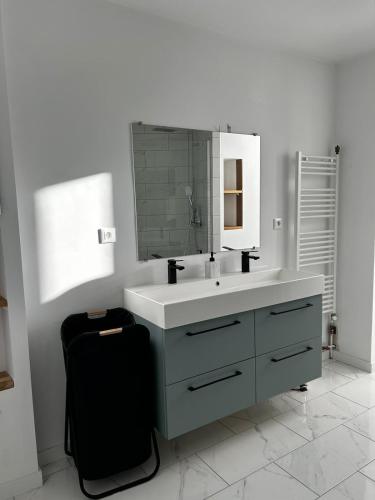 une salle de bain blanche avec un lavabo et un miroir dans l'établissement Bel appartement, à Toulon