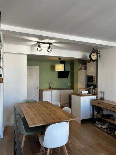 une cuisine et une salle à manger avec une table et des chaises en bois dans l'établissement Bel appartement, à Toulon